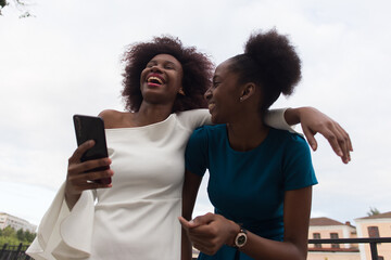 Happy African American women cuddle, friends