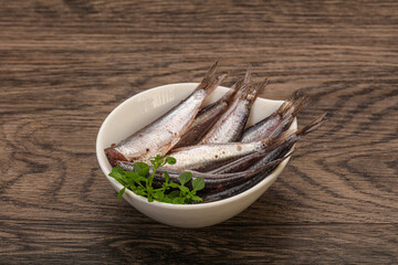 Anchovies in the bowl served basil leaves