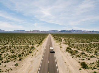Aerial view of a motorhome driving on a highway in the desert of USA California