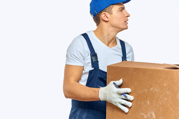 Man worker with box in hands delivery loading service work light background