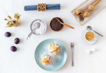 Plum and poppy seeds phyllo purses on a white wooden, delicious vegetarian dessert on a white wooden table.