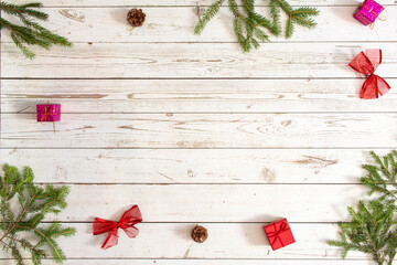 Christmas background. New Year, Flatlay. Green Christmas tree with festive decorations and toys on a light wooden background.