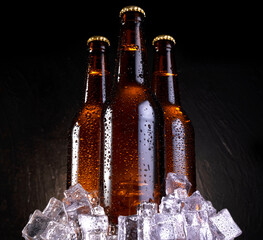 Cold beer with water drops, beer bottles with ice cubes