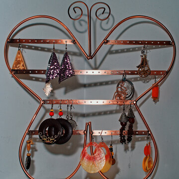 Objects for decorating a girl's bedroom. A metal butterfly hanging on the wall as a jewelry box for large earrings.