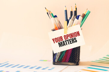 Card with text YOUR OPINION MATTERS on the pen box in the office. Diagram and white background