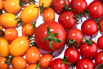 Red and yellow cherry tomatoes isolated on white background. Top view food background. Place for text