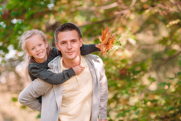 Fototapeta premium Family of dad and kid on beautiful autumn day in the park
