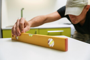 using of construction level in refurbishment. the builder checks the level of furniture installation