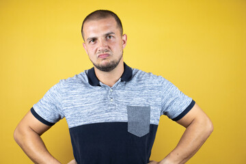 Russian man standing over insolated yellow background skeptic and nervous, disapproving expression...