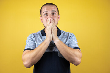 Russian man standing over insolated yellow background surprised with hand on head for mistake,...