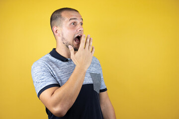 Russian man standing over insolated yellow background afraid and shocked with surprise expression, fear and excited face.