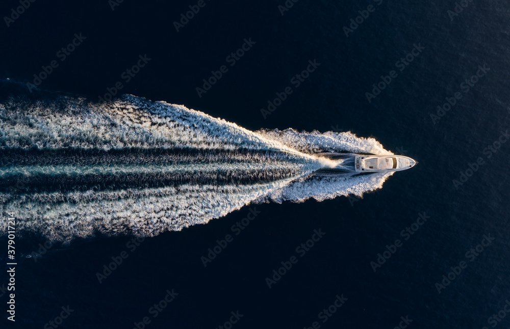 Wall mural aerial view on fast boat on blue mediterranean sea at sunny day. fast ship on the sea surface. seasc