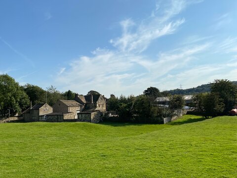 Rural view of Esholt village, with a large meadow, houses and a farm, on a sunny day near, Bradford, Yorkshire, UK