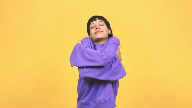 Young caucasian woman giving a hug, feeling of pride and happiness, affection towards yourself