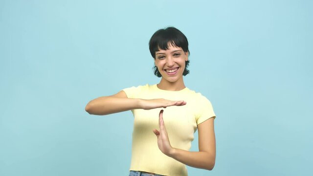 Young caucasian woman tired and bored, doing a timeout gesture, needs to stop because of work stress, time concept