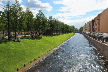 river in the city. Kryukov Canal in St. Petersburg and green grass on the shore. 