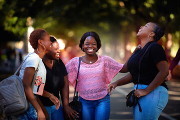 beautiful african american women, laughing friends having fun while walking in the park
