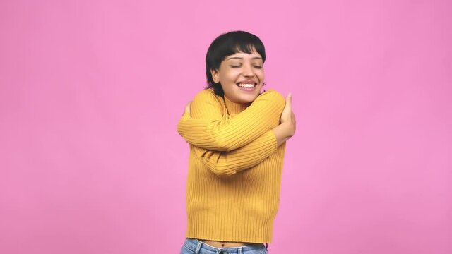Young caucasian woman giving a hug, feeling of pride and happiness, affection towards yourself