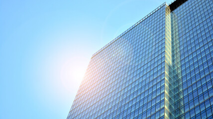 Office building, details of blue glass wall and sun reflections.