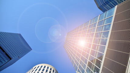 Office building, details of blue glass wall and sun reflections.