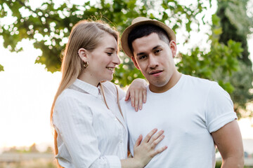 Obraz premium Young couple posing and watching camera. Latin man and Caucasian woman looking at camera