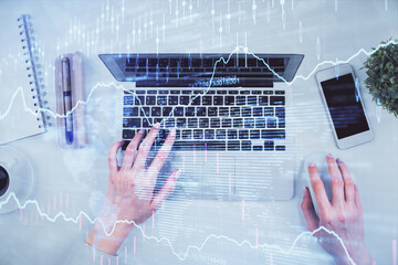 Double exposure of woman hands working on computer and forex chart hologram drawing. Top View. Financial analysis concept.