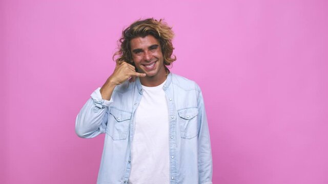 Young cool australian man showing a mobile phone call gesture with fingers