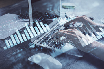 Double exposure of woman hands typing on computer and forex chart hologram drawing. Stock market...
