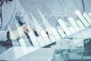 Fototapeta premium Double exposure of man's hands holding and using a phone and financial graph drawing. Analysis concept.
