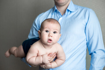 close-up portrait of a baby boy in the arms of dad