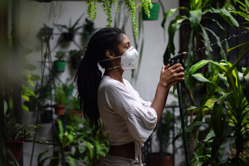 Young woman gardening in face mask