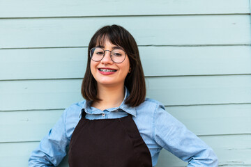 Portrait of brazilian female entrepreneur with big smile looking at camera in front of store...