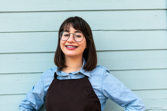 Portrait of brazilian female entrepreneur with big smile looking at camera in front of store facade. business, workplace, successful, entrepreneur, occupation concept..