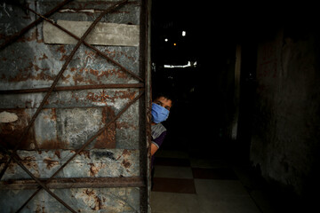A Palestinian child wearing a protective face mask stands outside his family's home amid the spread of the novel coronavirus (COVID-19) pandemic in Khan Yunis in southern Gaza Strip, Gaza Strip.