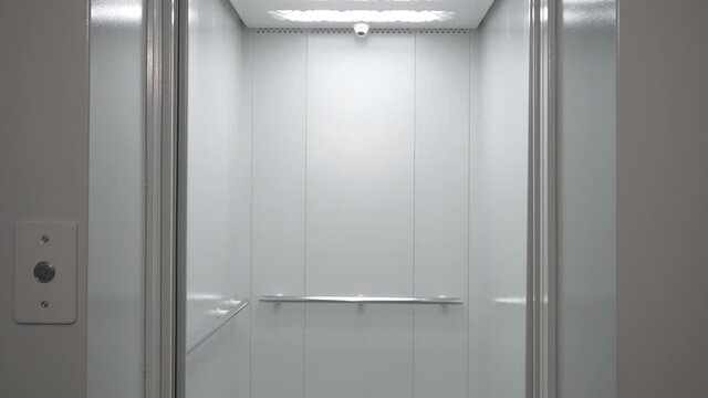 Empty elevator in a residential building or office. Modern elevator or lift doors made of metal smoothly open and close 