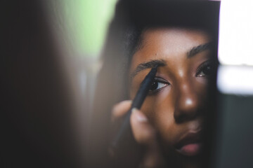 Young black woman applying make up