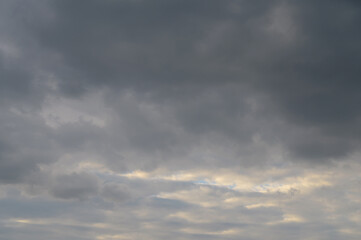 Abstract background of gray fluffy clouds on a bright blue sky