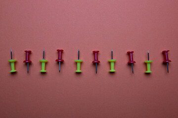 red and tellow colored pushpins on brown background