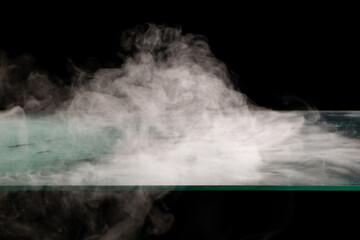 Fototapeta na wymiar White smoke swirling spreads over the surface flowing down from the edges on a black background