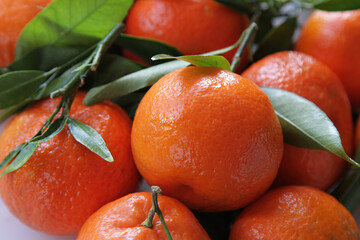 Ripe orange mandarin with leaves on a white square plate. Ripe tangerin with leaves