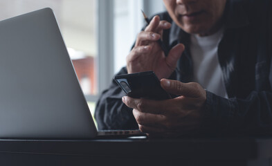 Business man using mobile phone making facetime video calling via zoom online meeting app while...
