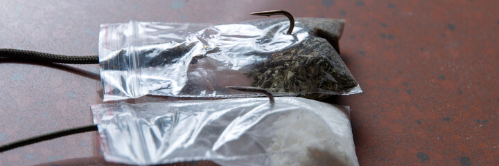 drug trap concept: a pair of drug sachets with triple hooks inside