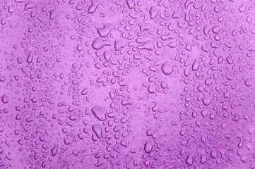 small and large drops of condensation on frosted colored glass