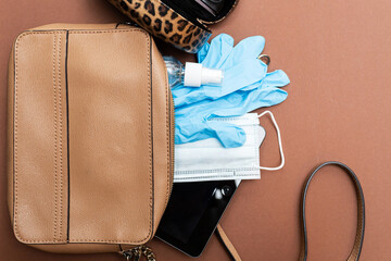 What's in a lady's bag in 2020? Protective face mask, sanitizer, gloves and tablet. Health care...
