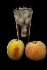 photo of frozen apples and glasses with ice on a black background