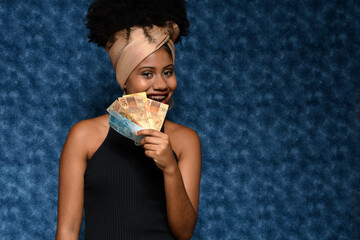 woman smiles  holding brazilian money notes