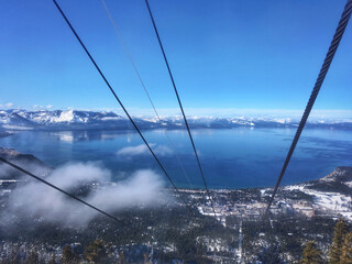 Aerial view of Lake Tahoe on a sunny winter day, with vivid blue skies, as seen from inside a gondola © Jen