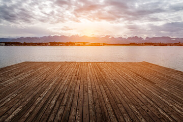 Fototapeta na wymiar Water wooden pier on the lake at sunset time