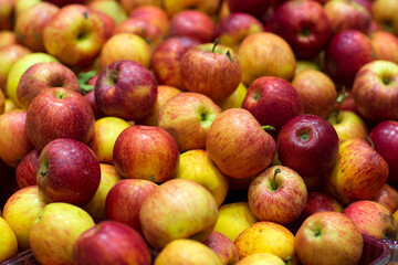 Background of apples fruits. Selective focus. Fresh Juicy apples Heap on Market Stall red apples in the market. Blurred background.