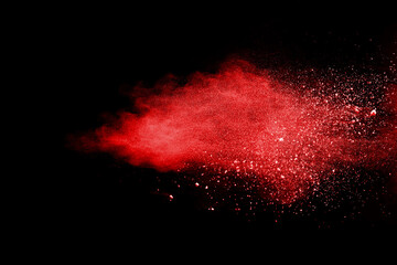 Red powder explosion on black background. Paint Holi.